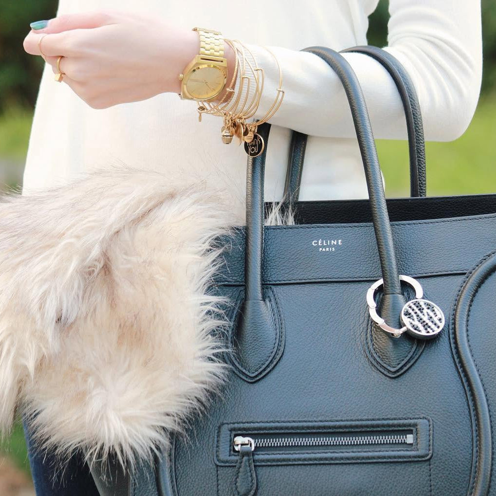A crystal Luxe Link hook clipped to a black quilted shoulder bag