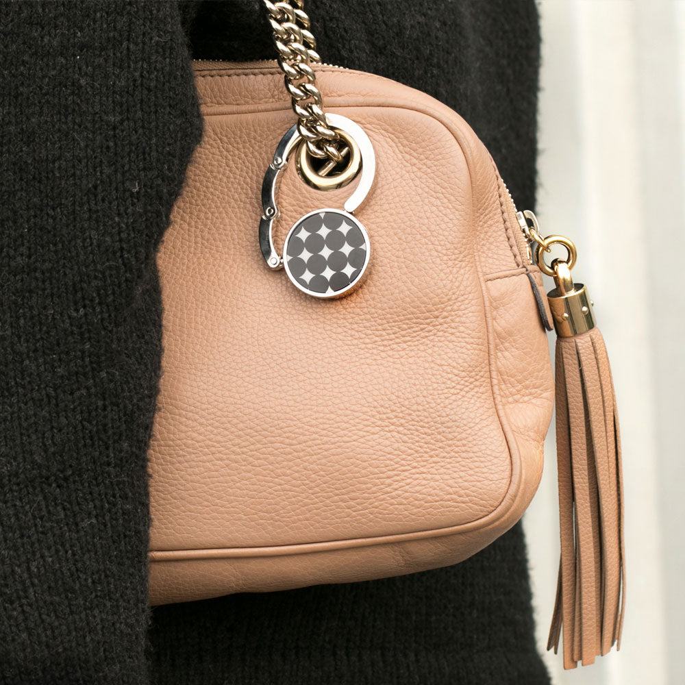 The hook closed and clipped to a bag strap as a charm